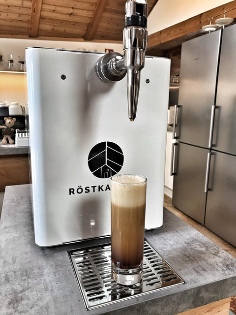 Glas gefüllt mit Nitro Kaffee vor einer Zapfanlage