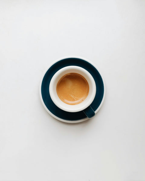 Espresso Tasse mit Espresso befüllt wird von oben fotografiert und steht auf einem weißen Untergrund